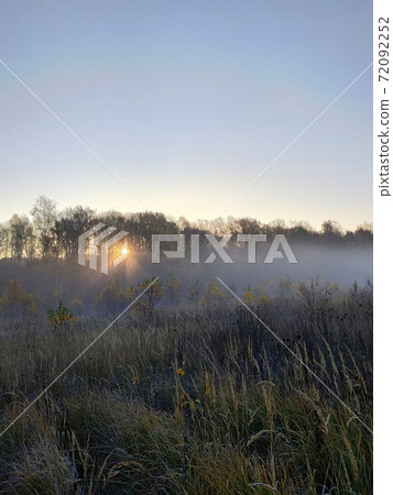 Beautiful thick fog sunrise Autumn Fall landscape over fields with treetops visible through fog Beautiful thick fog sunrise Autumn Fall landscape over fields with treetops visible through fog 72092252