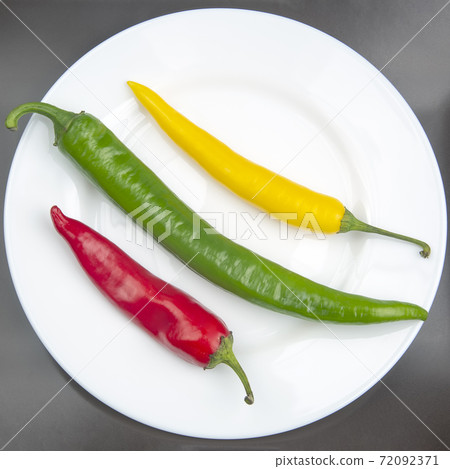 yellow, red and green hot chili on a plate. Pepper. Vegetable vitamin food. 72092371