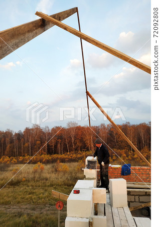 The masonry mooring the wall in the fresh air with a trowel and glue solution The masonry mooring the wall in the fresh air with a trowel and glue solution 72092808