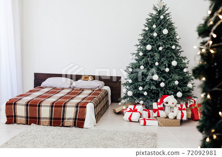 bedroom with bed decor new year and beautiful Christmas tree with gifts bedroom with bed decor new year and beautiful Christmas tree with gifts 72092981
