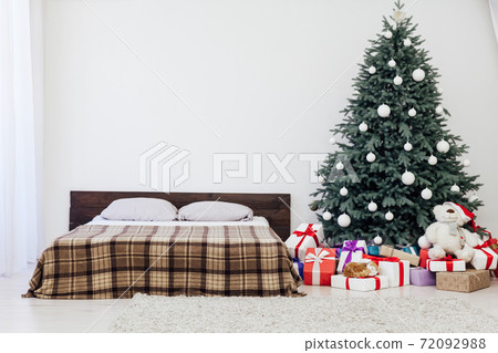 bedroom with bed decor new year and beautiful Christmas tree with gifts bedroom with bed decor new year and beautiful Christmas tree with gifts 72092988
