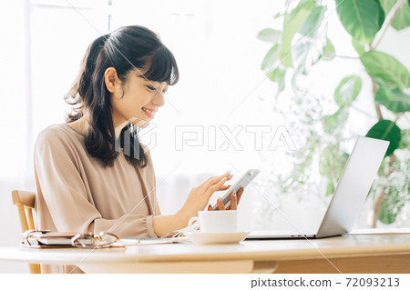 Teleworking woman with a smartphone 72093213