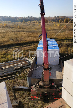 unloading of blocks by automobile crane on the construction site unloading of blocks by automobile crane on the construction site 72093409