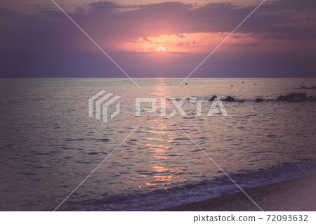 Pebbles on the beach in the sunset light. Blurred 72093632