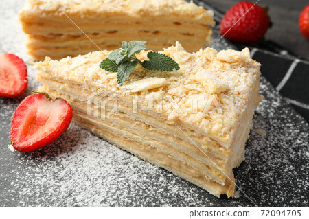 Pieces of Napoleon cake with strawberry and sugar powder, close up Pieces of Napoleon cake with strawberry and sugar powder, close up 72094705