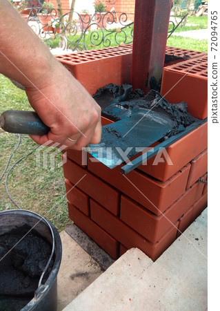 The builder uses a trowel for masonry bricks The builder uses a trowel for masonry bricks 72094765