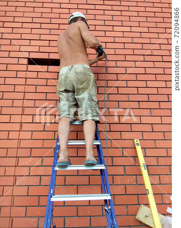 The builder performs work on the ladder 72094866