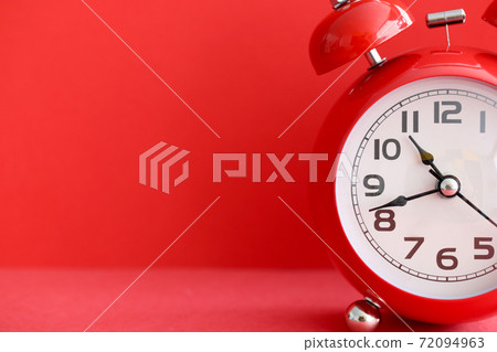 Red alarm clock on red background closeup 72094963