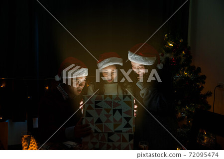 happy family open the Christmas present together and surprise their daughter during the dinner happy family open the Christmas present together and surprise their daughter during the dinner 72095474