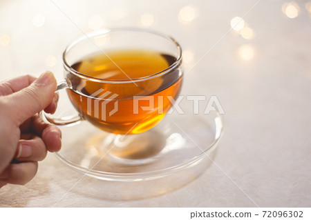 舉起手來喝茶的婦女。回家時間，休息時間。 72096302