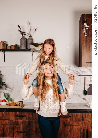 Smiling mother playing with child in kitchen at home 72096466