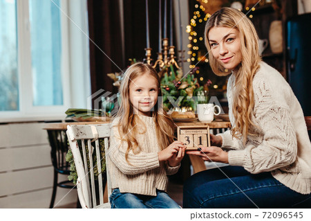 Happy family holding a wooden calendar for DEC 31 . 72096545