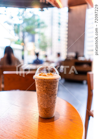 Glass of Starbuck Coffee Frappuccino Blended Beverages served at wood table in starbuck shop in Taiwan. 72097229