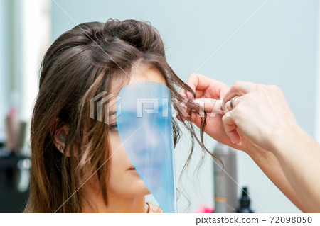 Hairdresser making hairstyle. 72098050