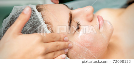 Young woman getting facial massage 72098133