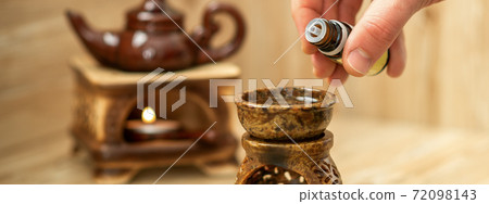 Hand pours essential oil to diffuser Hand pours essential oil to diffuser 72098143