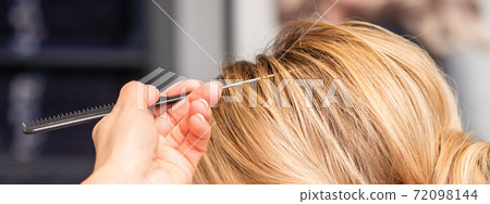 Woman receiving her hair done Woman receiving her hair done 72098144
