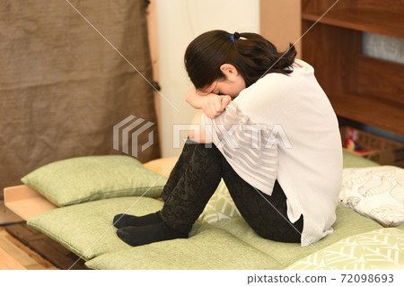 Depressed woman holding her knees 72098693