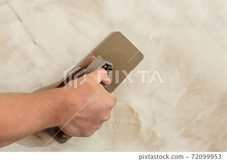 polishing the Venetian plaster on the wall master polishing the Venetian plaster on the wall master 72099953