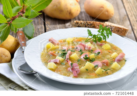 Freshly made potato soup with bacon strips and sausage wheels, served with bread 72101448