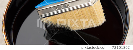 Roofer's hand holding a brush with bituminous mastic Roofer's hand holding a brush with bituminous mastic 72101802