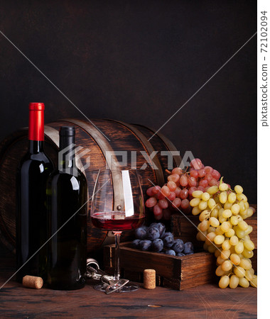 Wine bottles, grapes and glass of red wine 72102094