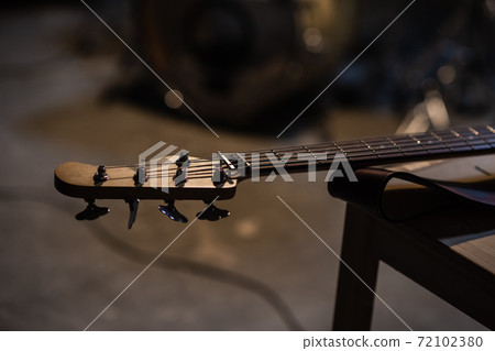 tuning pegs and fretboard bass guitar close up on the background of the musician's apartment with copy space. 72102380