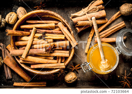 Fresh honey with the cinnamon sticks in a bowl . 72103664