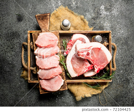 Raw pork meat with herbs and spices in a tray. 72104425