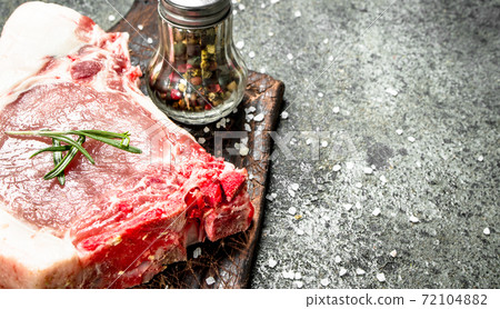 Raw pork steak with herbs and spices. 72104882