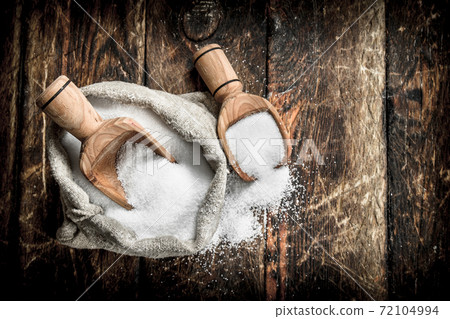 Salt in a wooden spoon. 72104994