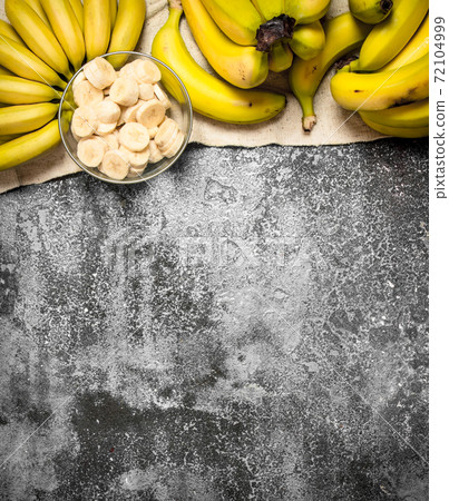 Fresh bananas with pieces of sliced bananas in a bowl. Fresh bananas with pieces of sliced bananas in a bowl. 72104999