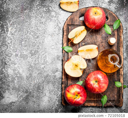 Apple cider vinegar with fresh apples on cutting Board. Apple cider vinegar with fresh apples on cutting Board. 72105018