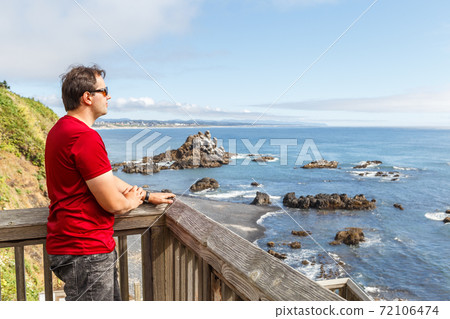 Man looking at Cobble Beach below Yaquina Headland 72106474