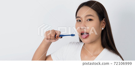 Asian teen facial with braces and toothbrush smiling to camera to show dental orthodonic teeth which include professional metal wire material from orthodontist. studio shot white background.  72106999
