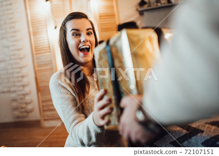 a guy and a girl celebrate the new year together. and give each other gifts 72107151