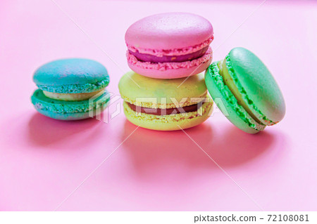 Sweet almond colorful pink blue yellow green macaron or macaroon dessert cake isolated on trendy pink pastel background. French sweet cookie. Minimal food bakery concept. Flat lay top view, copy space Sweet almond colorful pink blue yellow green macaron or macaroon dessert cake isolated on trendy pink pastel background. French sweet cookie. Minimal food bakery concept. Flat lay top view, copy space 72108081