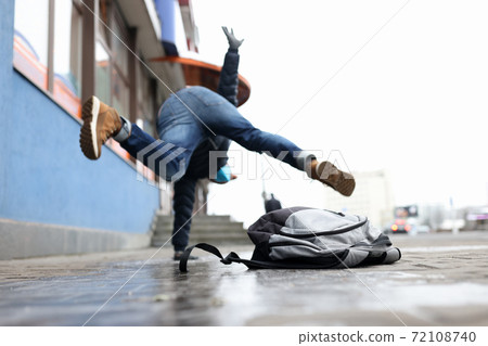 Man in winter dress slip on sidewalk with ice closeup background Man in winter dress slip on sidewalk with ice closeup background 72108740