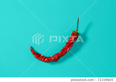 Red hot pepper dry pod casts shadow on a marine blue background.  72109685