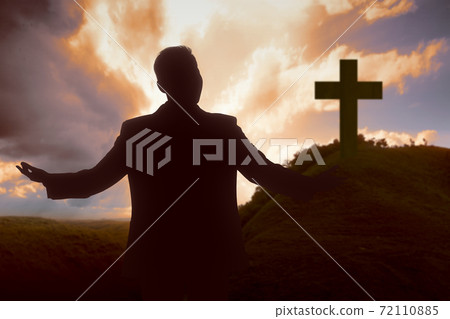 Silhouette of businessman raised hands and praying to god 72110885