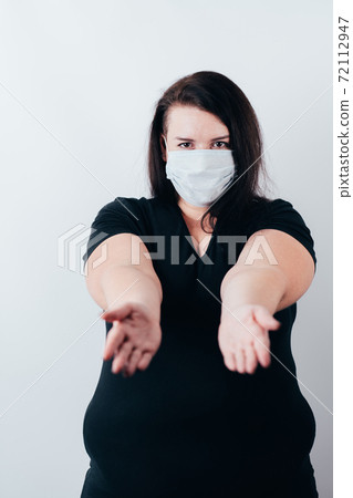 Woman in medical mask stretching hands to camera 72112947