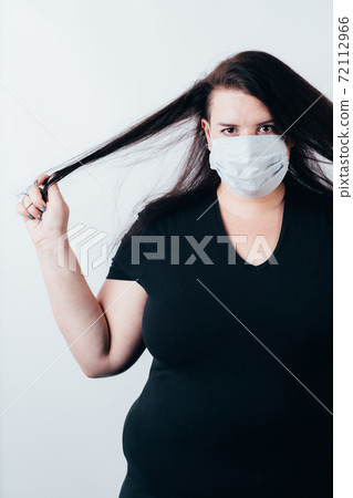 Woman in medical mask doing hair care Woman in medical mask doing hair care 72112966