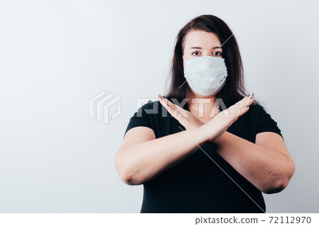 Woman in protective face mask showing stop sign Woman in protective face mask showing stop sign 72112970