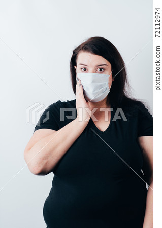 Worried woman in protective medical mask 72112974