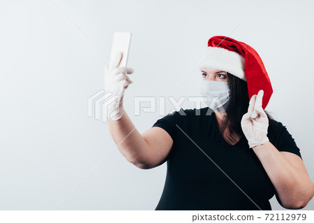Woman in face mask posting selfie in social media 72112979