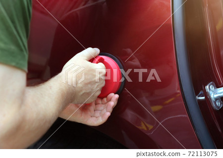 Man fixing car dent by himself 72113075