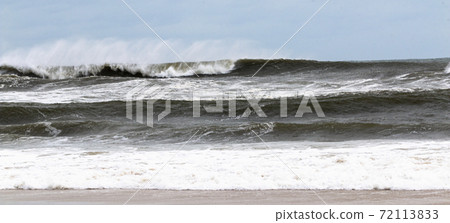 Wide view of rough ocean on windy day with a blue sky 72113833