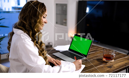 Young business women at her laptop green screen display Young business women at her laptop green screen display 72117177