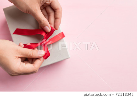 Paper gift box decorated with red ribbon for giving Paper gift box decorated with red ribbon for giving 72118345