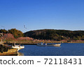 A row of cherry blossom trees along the sea seen from a small fishing port 72118431